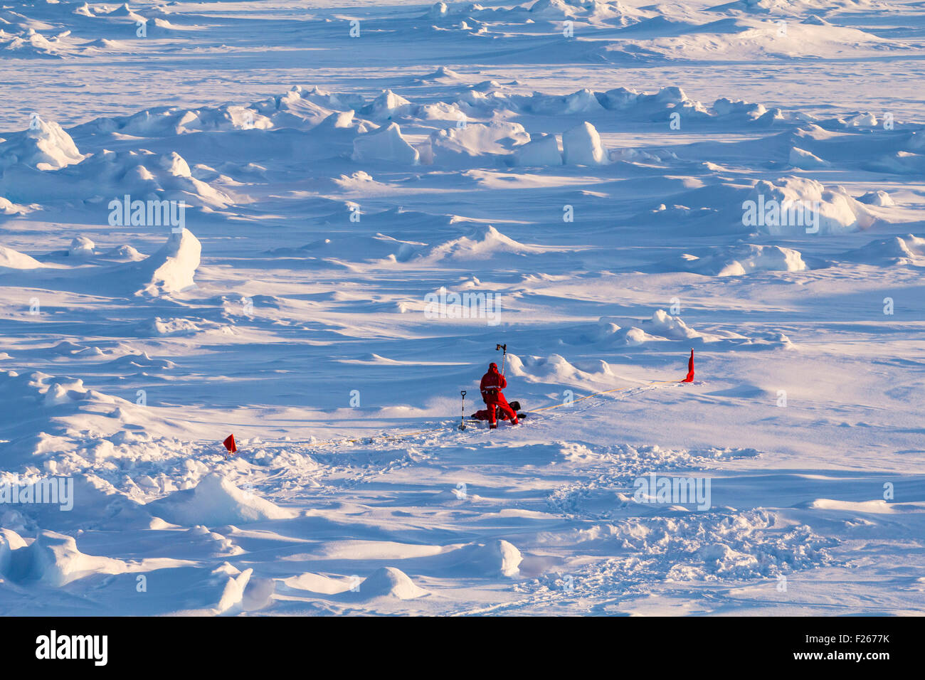 Zwei polare Wissenschaftler in roter polar Kleidung arbeiten an Eisbohrkernen über einer Eisscholle Stockfoto