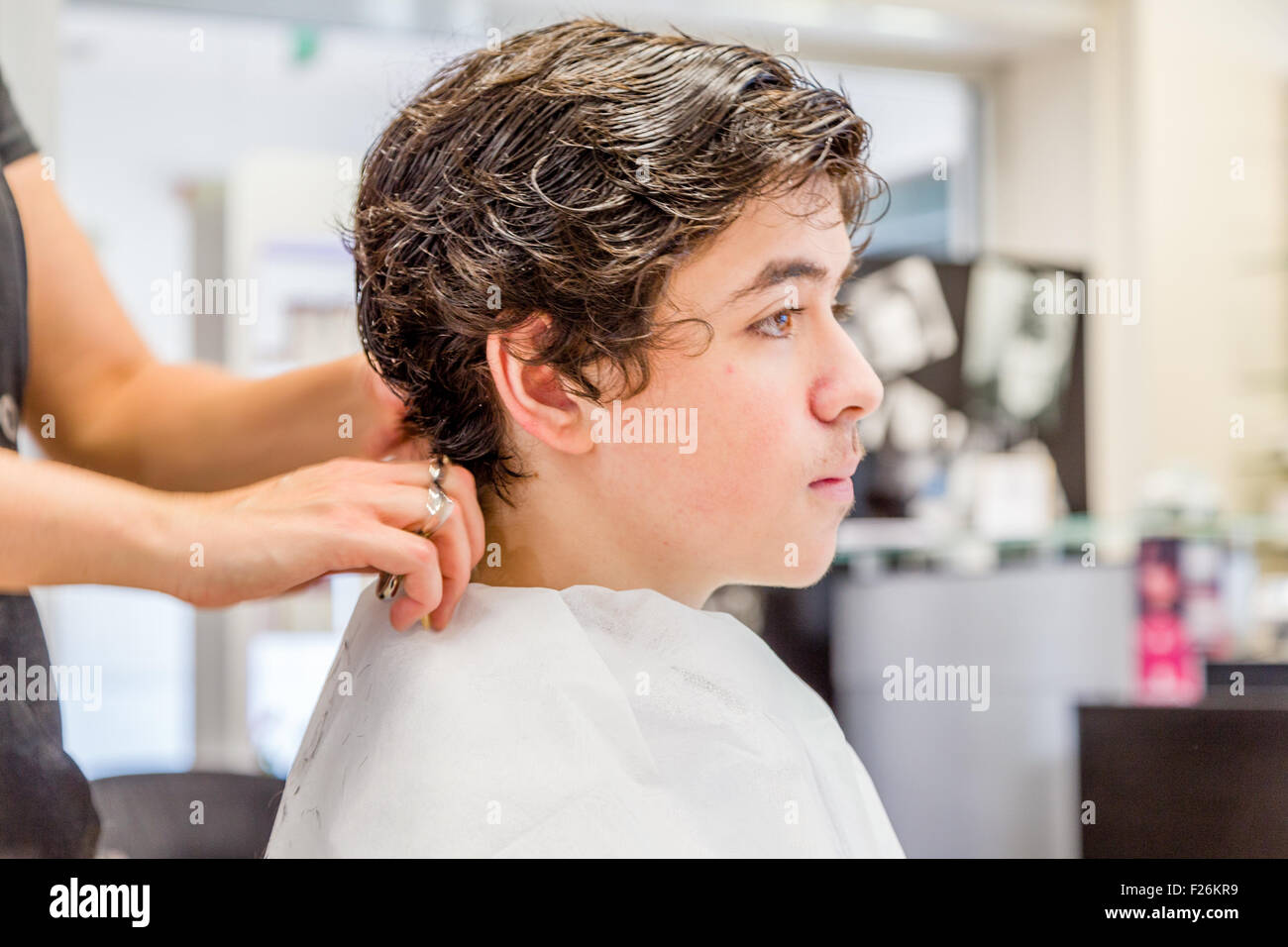 Süße kaukasische Teenager sitzen auf dem Friseursalon für einen Haarschnitt Stockfoto