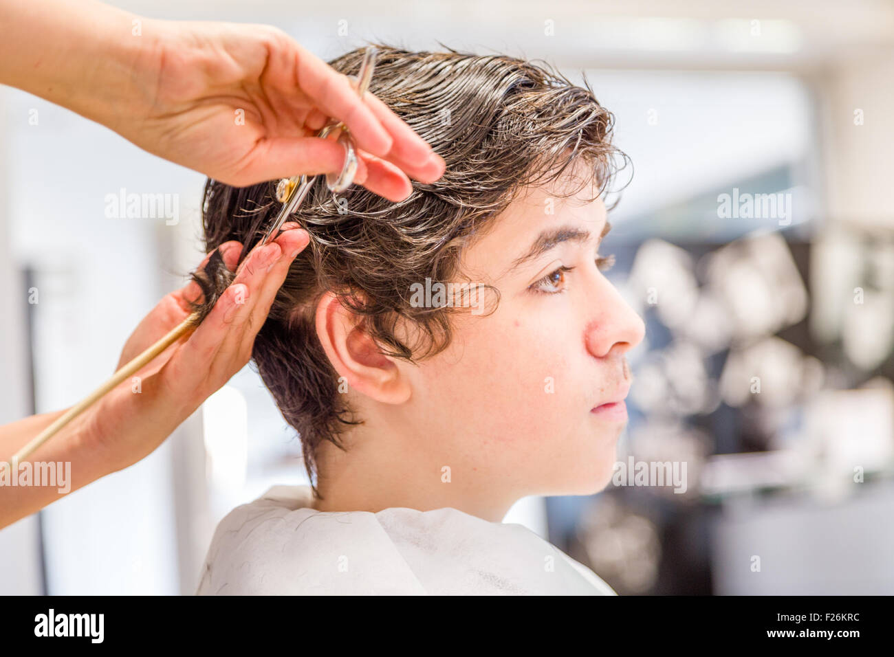 Süße kaukasische Teenager sitzen auf dem Friseursalon für einen Haarschnitt Stockfoto