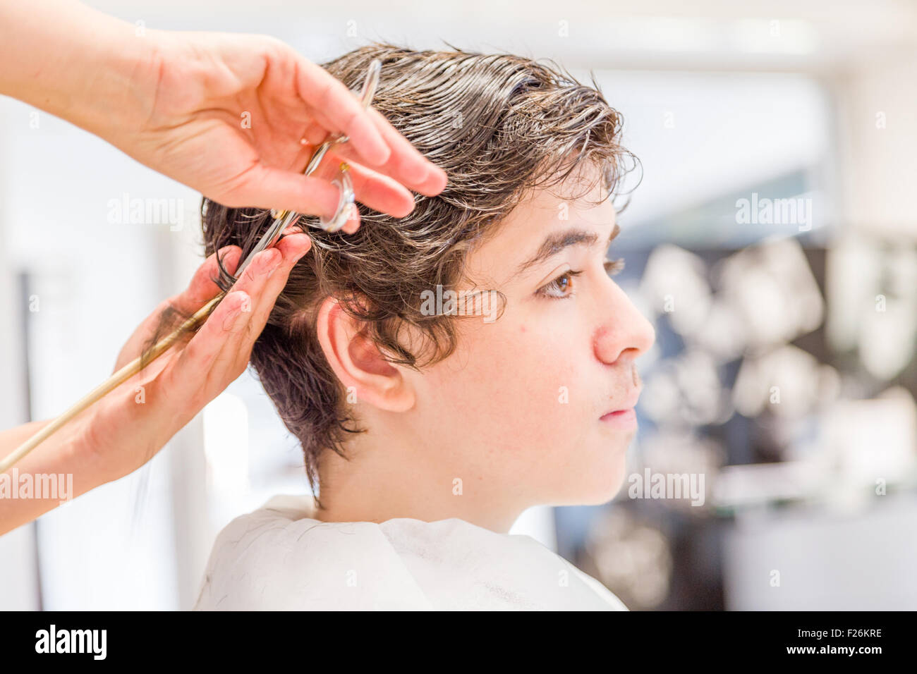 Süße kaukasische Teenager sitzen auf dem Friseursalon für einen Haarschnitt Stockfoto