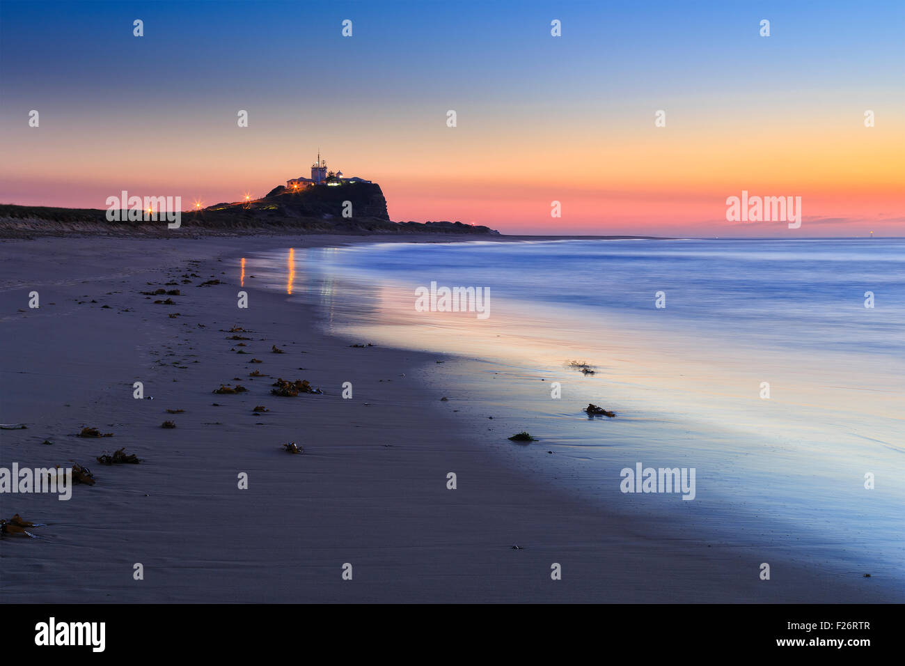 Berühmte Nobbys Kopf und Leuchtturm in Newcastle Australien bei Sonnenaufgang vom Sandstrand Stockfoto