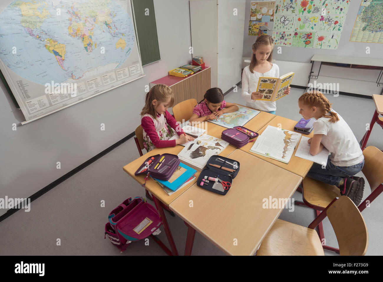Schülerinnen und Schüler lesen von Büchern im Unterricht, München, Bayern, Deutschland Stockfoto