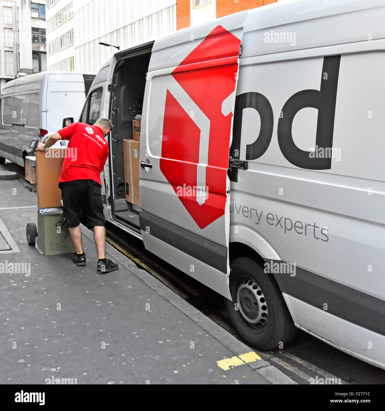 Fahrer eines Lieferwagens, der Pakete vom DPD Supply Chain Service auf den Wagen lädt und Pakete an ein Unternehmen in London, England, UK liefert Stockfoto