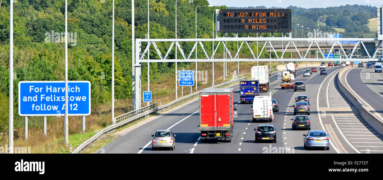 Autobahn M25 vier Lane Gantry montiert elektronische Informationen anmelden Herkömmliche blaue Schilder am Straßenrand neben dem Seitenstreifen Brentwood Essex England Großbritannien Stockfoto