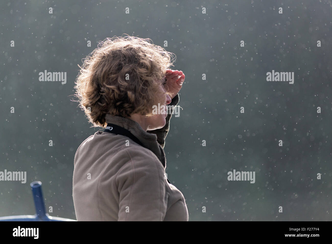 Porträt einer Frau mit Blick vom Deck eines Bootes bei leichtem Regen, südöstlichen Alaska. Stockfoto