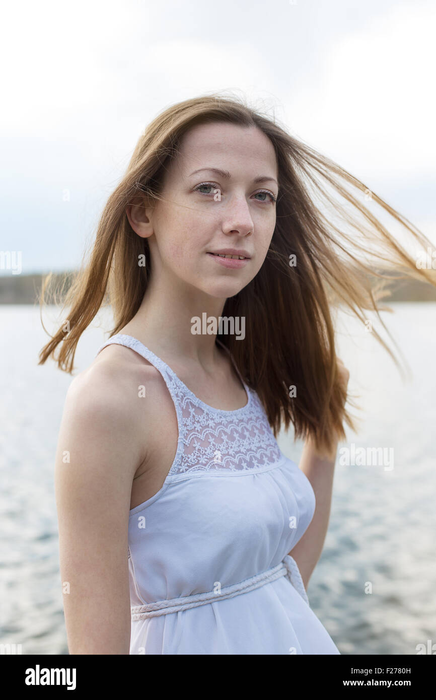 Sommersprossige glückliches Mädchen Blick in die Kamera bei windigem Wetter Stockfoto