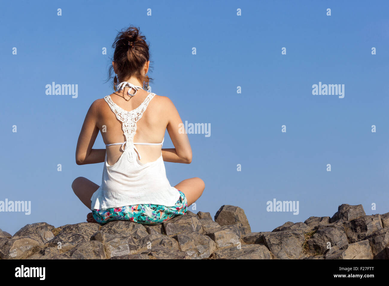 Frau Yoga Pose auf vulkanischem Felsen Stockfoto