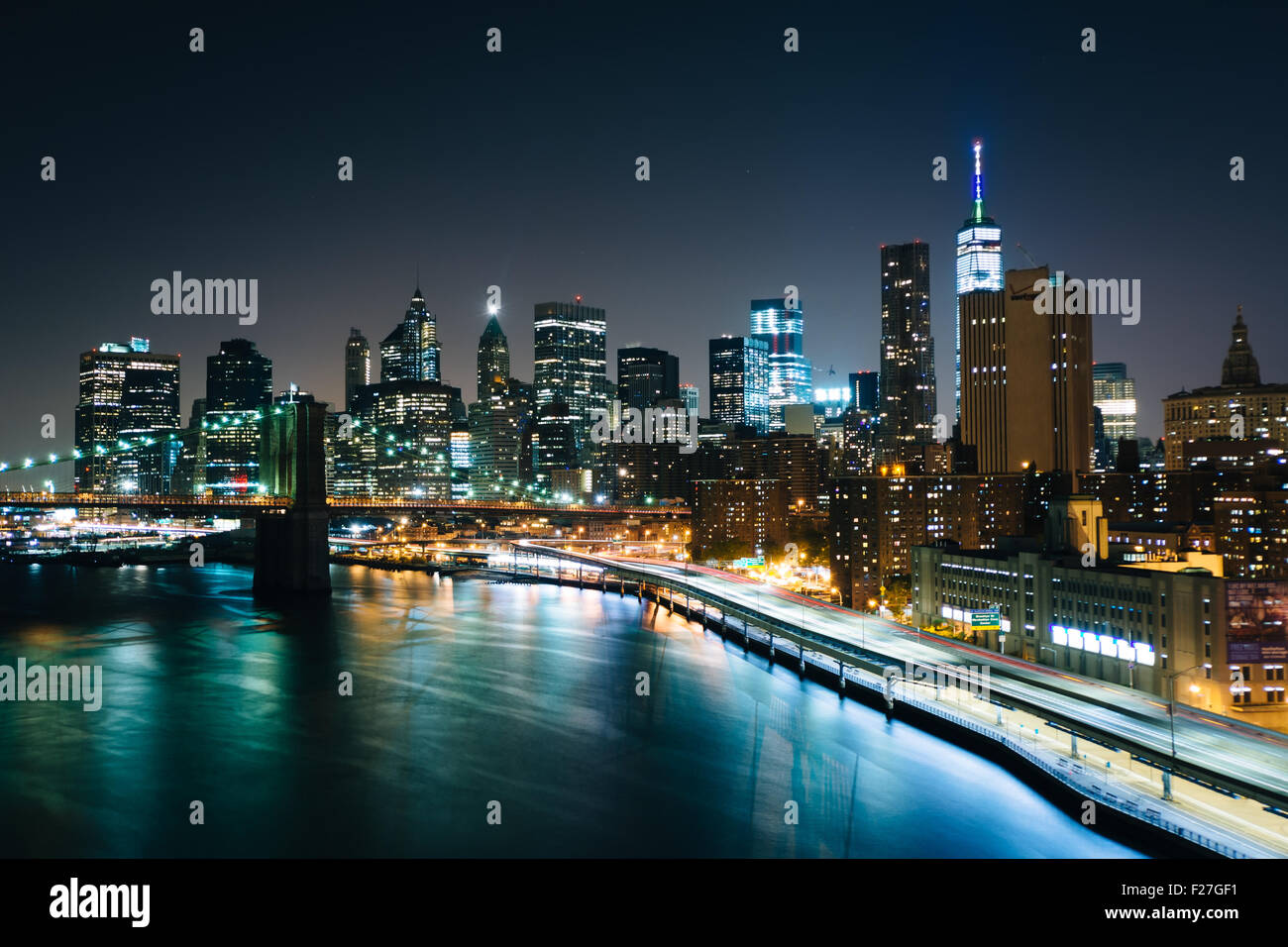 Blick auf den East River und Lower Manhattan Skyline bei Nacht, von der Manhattan Bridge Gehweg, New York. Stockfoto