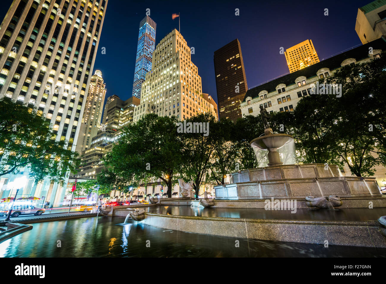 Die Pulitzer-Brunnen am Grand Army Plaza und Gebäuden in Midtown Manhattan in der Nacht in New York. Stockfoto