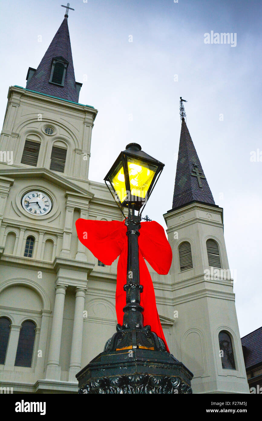 Ein großer roter samt Bogen hängt von einer antiken Laternenpfahl vor St. Louis Cathedral in Jackson Square, New Orleans, LA Stockfoto