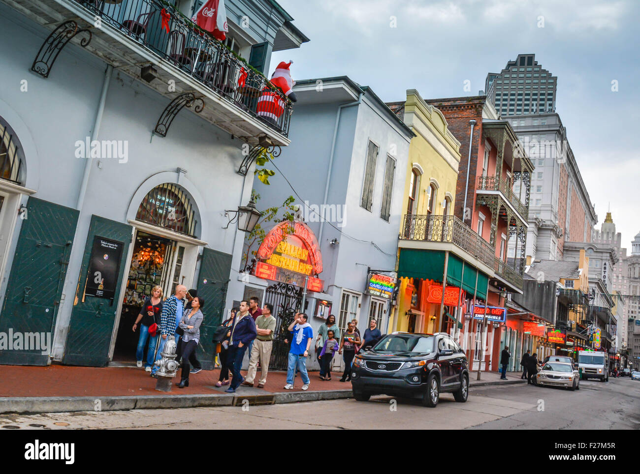 Touristen schlendern die berühmte Bourbon Street spät in den Tag mit Leuchtreklamen und Tavernen im French Quarter, New Orleans, LA Stockfoto