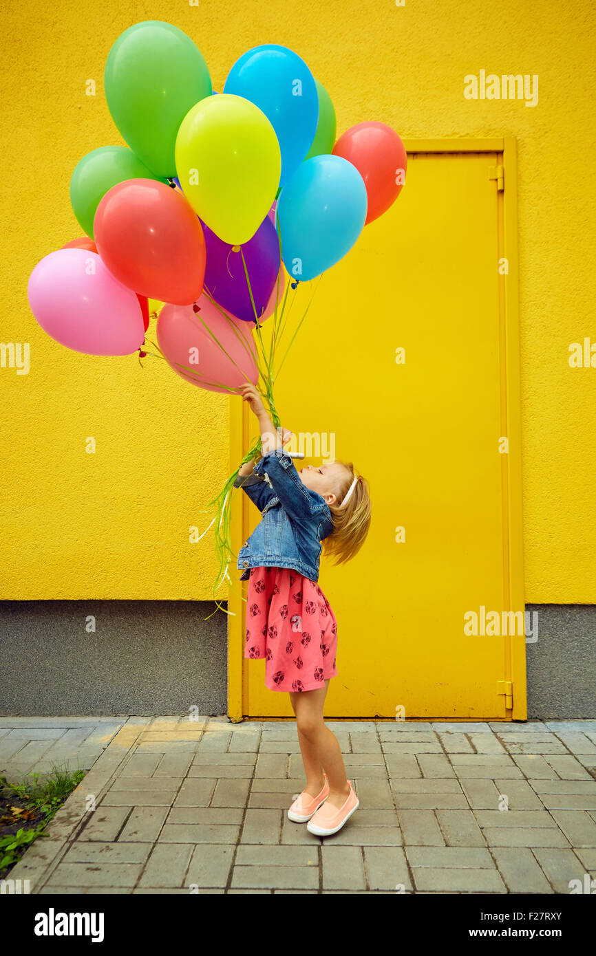 glückliche kleine Mädchen im Freien mit Luftballons Stockfoto