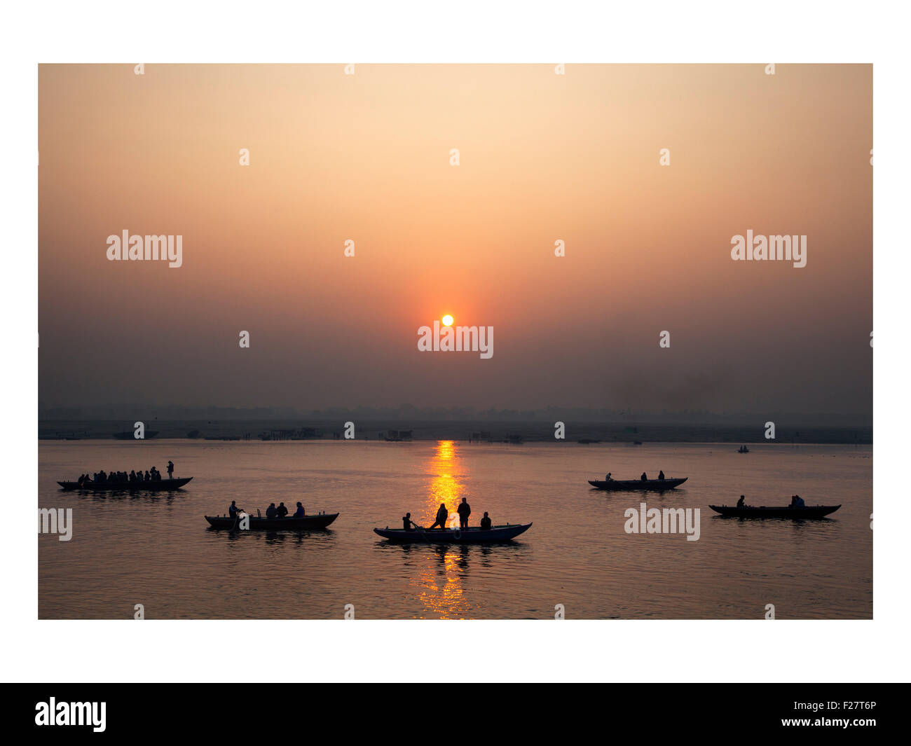Bei Sonnenaufgang treiben Boote den Ganges River in Varanasi, Indien, hinunter. Stockfoto