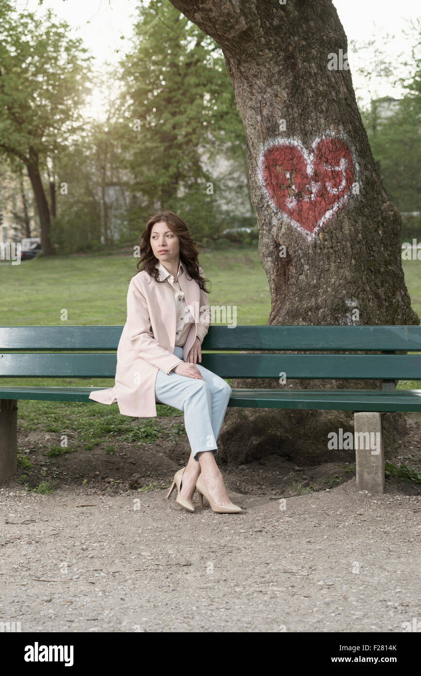 Reife Frau wartet auf ihr Date auf Park Bench, Bayern, Deutschland Stockfoto