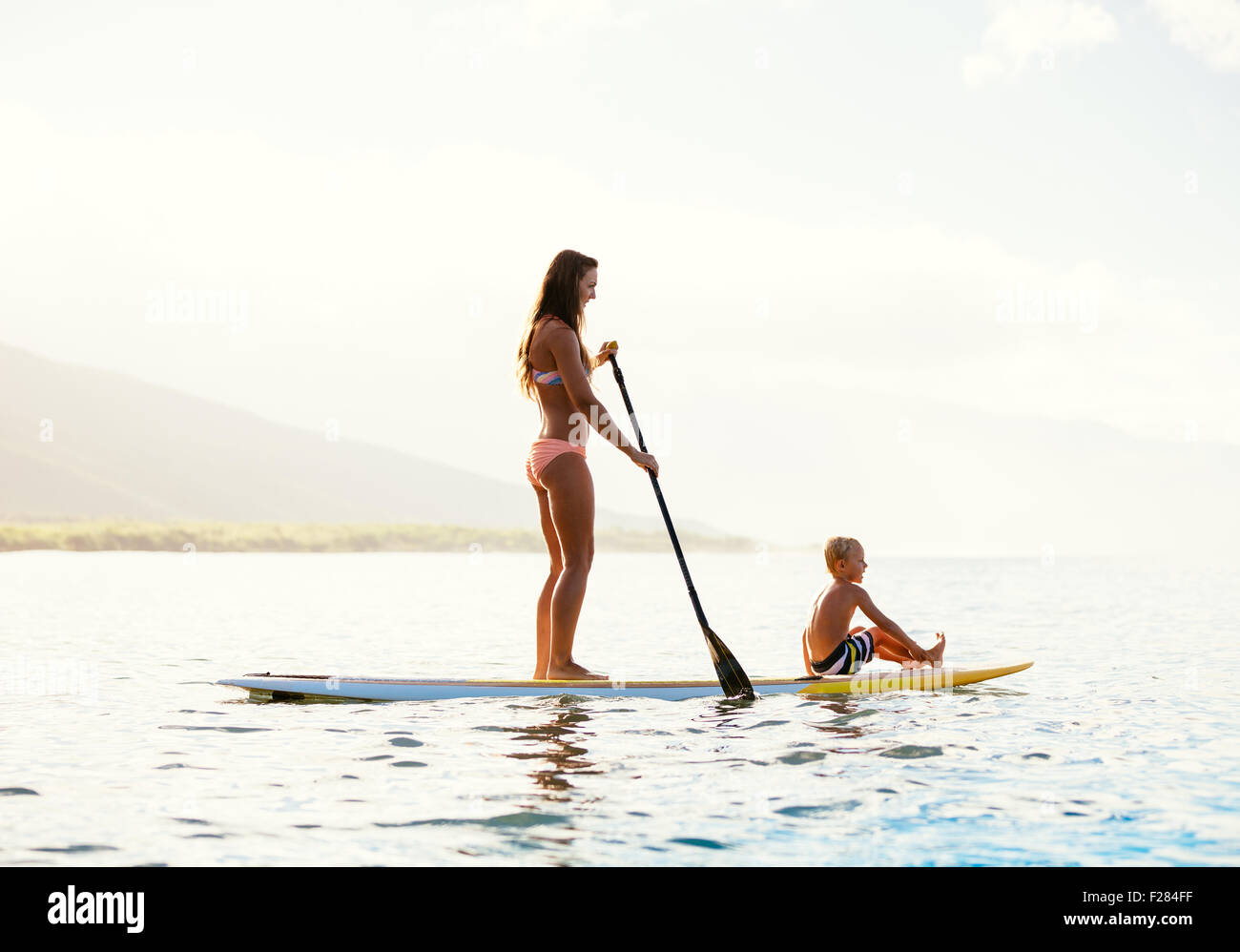 Mutter und Sohn Stand Up Paddeln zusammen Spaß im Ozean Stockfoto