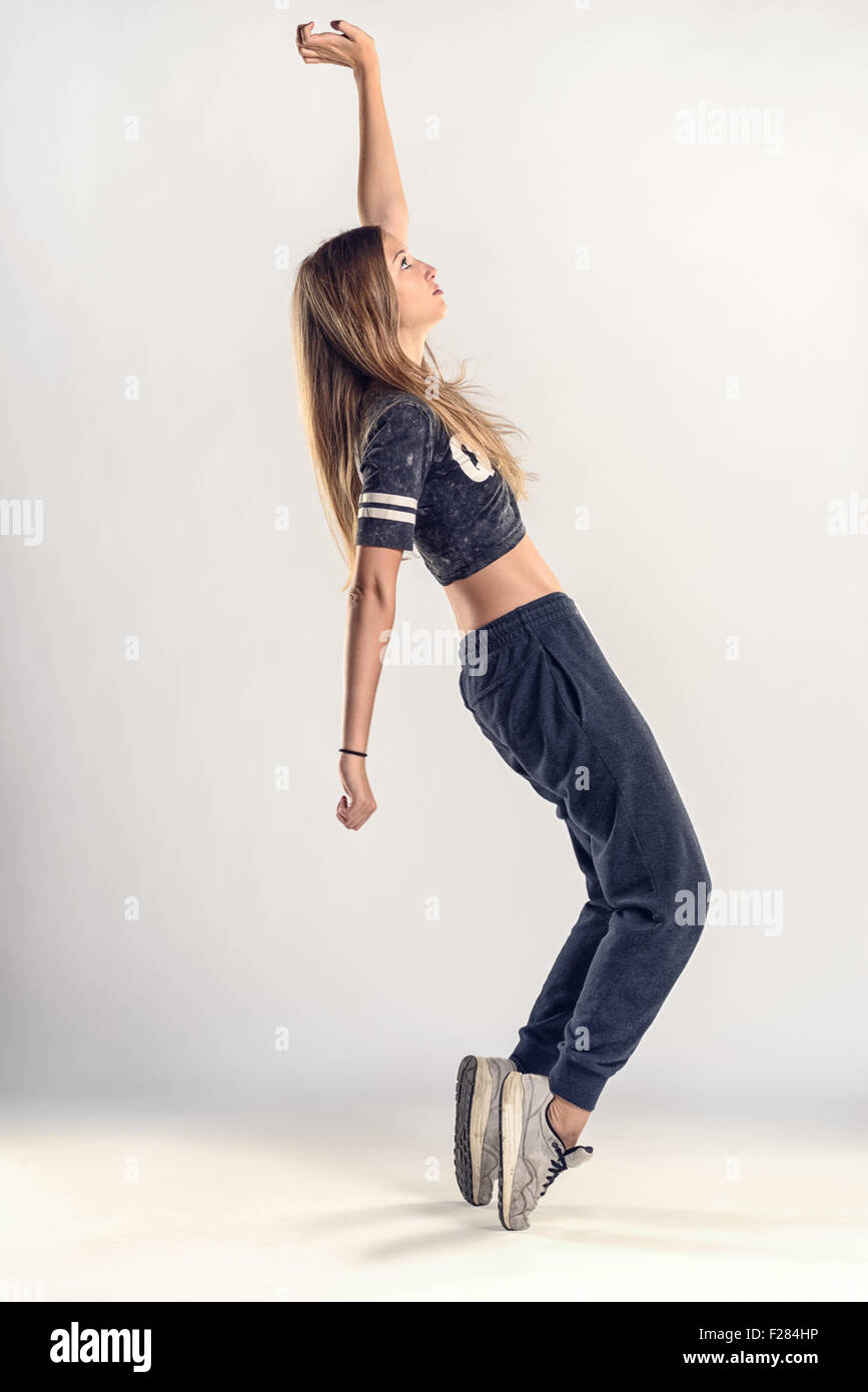 Voller Länge Schuss von einem jungen weiblichen Hip Hop Tänzer in der Zehenspitzen Lage gegen graue Wand Hintergrund. Stockfoto