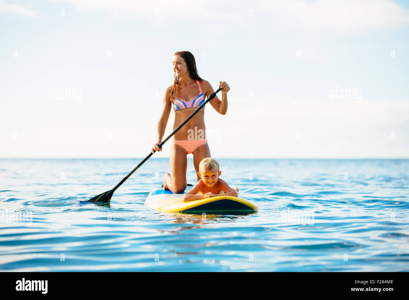 Mutter und Sohn Stand Up Paddeln zusammen Spaß im Ozean Stockfoto