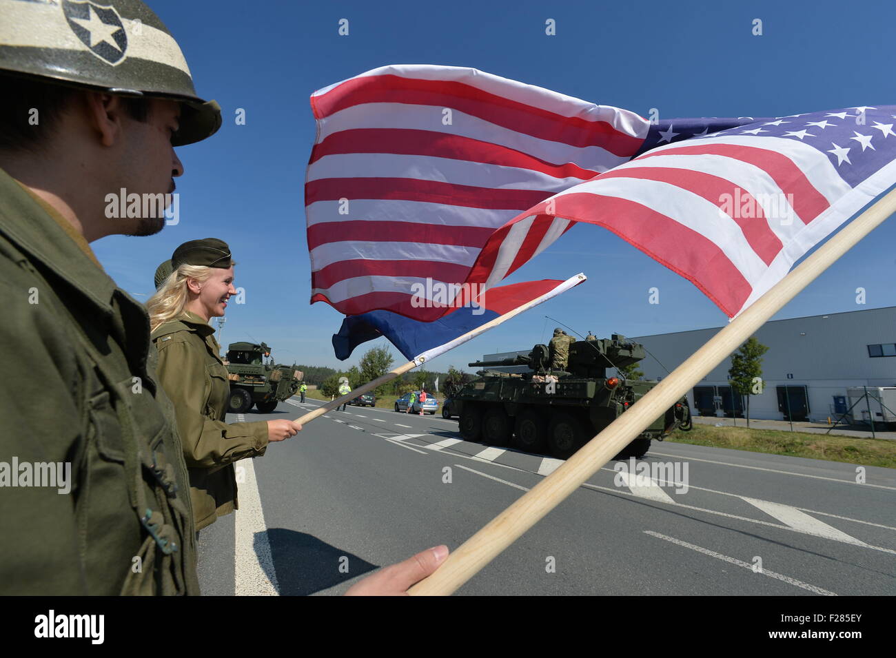 3. Armee Club Mitglieder Welle mit USA Flaggen begruesse Bestandteil der US-Militärkonvoi, die der Tschechischen Republik auf dem Weg von Bayern nach einer NATO-Übung in Ungarn Kreuzung Ostrov u Stribra, auf Sonntag, 13. September 2015 zu überqueren. Der Konvoi von insgesamt 150 Fahrzeuge und 550 Truppen ist ihre Transit durch die Tschechische Republik am Montag abgeschlossen. (Foto/Pavel Nemecek CTK) Stockfoto