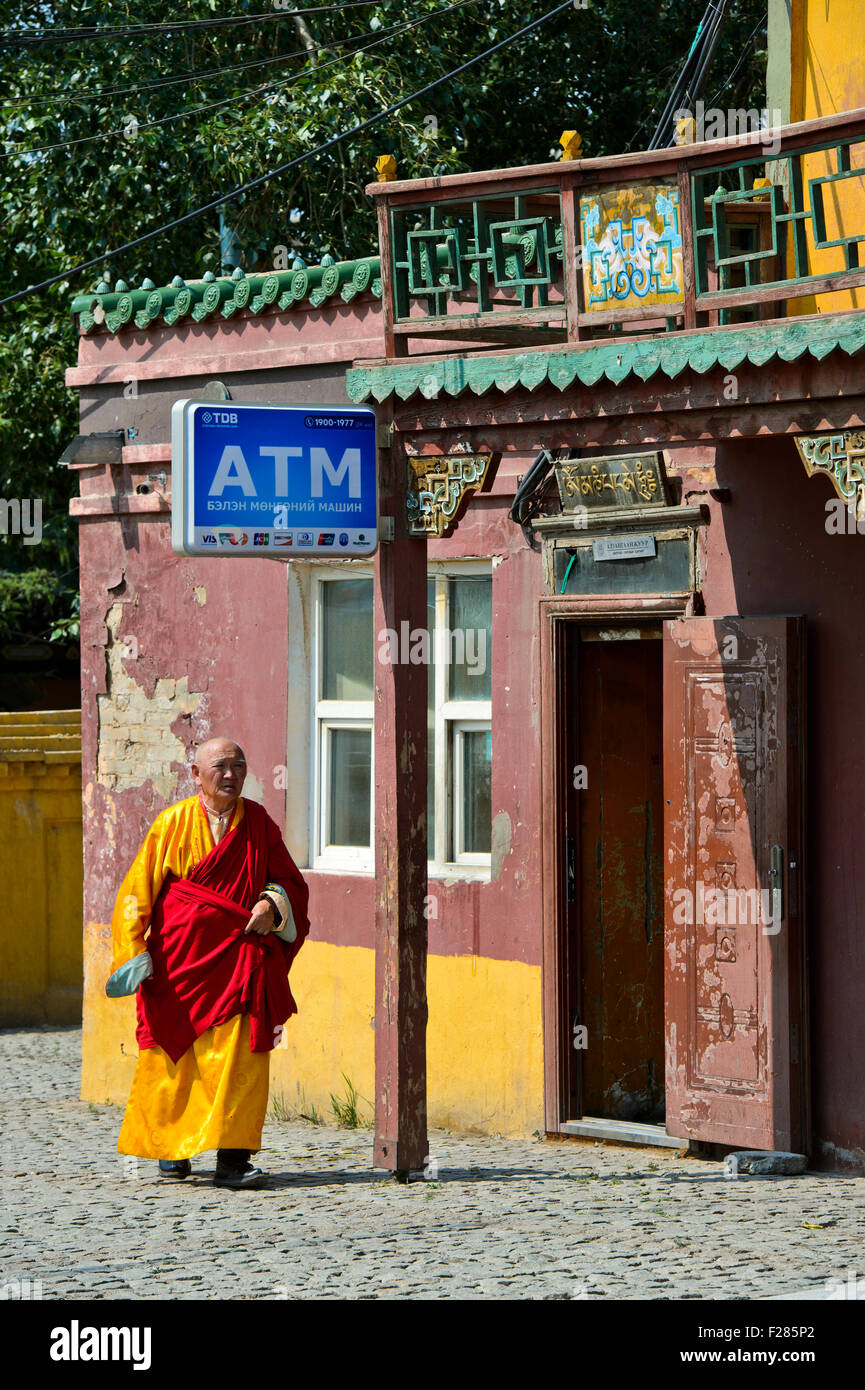 Mönch, vorbei an einem Gebäude für Geldautomaten in das buddhistische Gandan Kloster, Ulaanbaatar, Mongolei Stockfoto