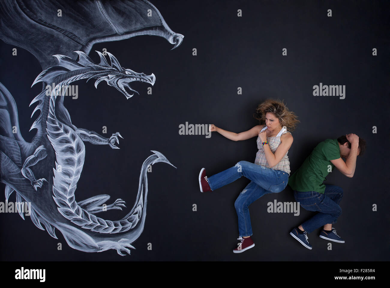 Junge schwangere Frau seinen Mann gegen eine Zeichnung Drachen zu schützen. Stockfoto