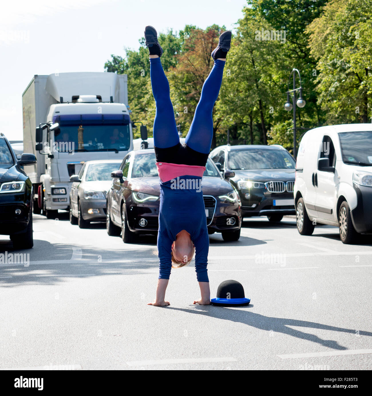 Akrobatin Macht Handstand Auf der Kreuzung Im Autoverkehr Stockfoto