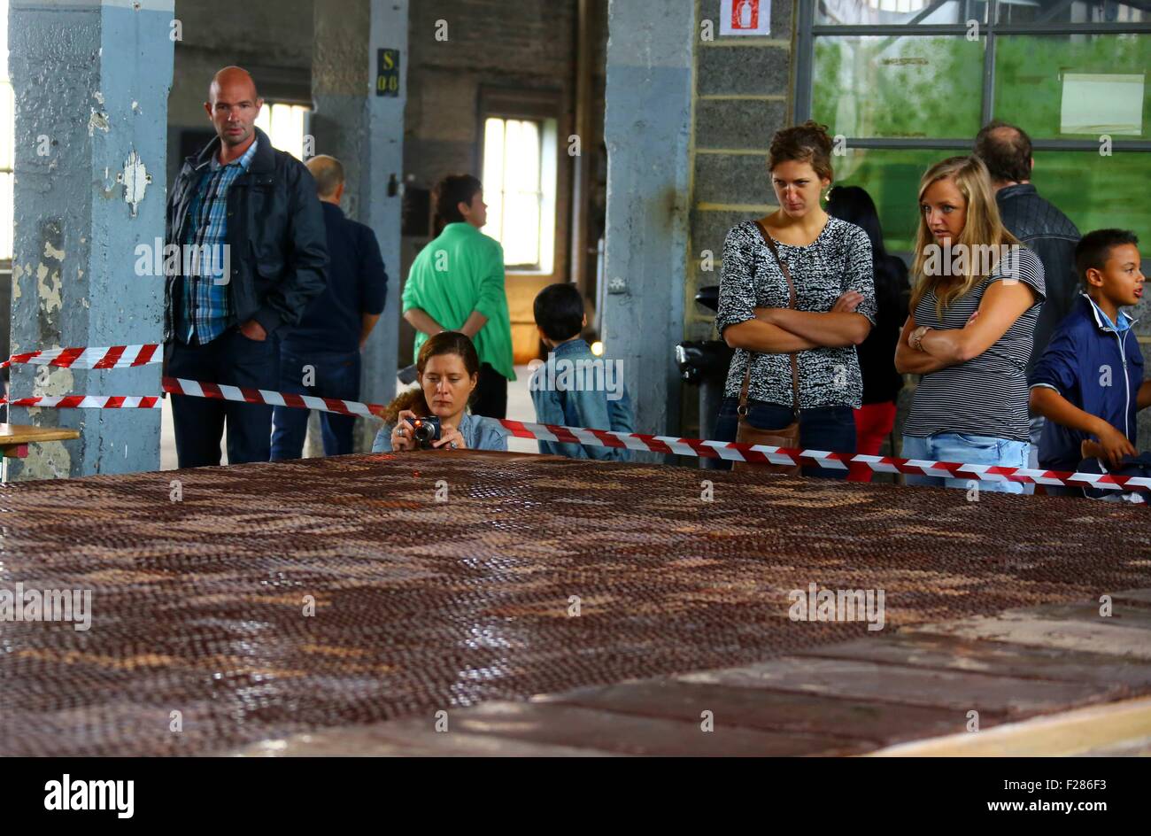 Brüssel, Belgien. 13. Sep, 2015. Besucher sehen eine riesige Schokolade in einer Schokoladenfabrik in Tongeren, Belgien, 13. September 2015. Die Fabrik produzierte Schokolade, 21 Meter lang, 5 Meter in der Breite und 1000 kg Gewicht und legte es auf Anzeige am Sonntag, im Rahmen des belgischen Heritage Days. Bildnachweis: Gong Bing/Xinhua/Alamy Live-Nachrichten Stockfoto