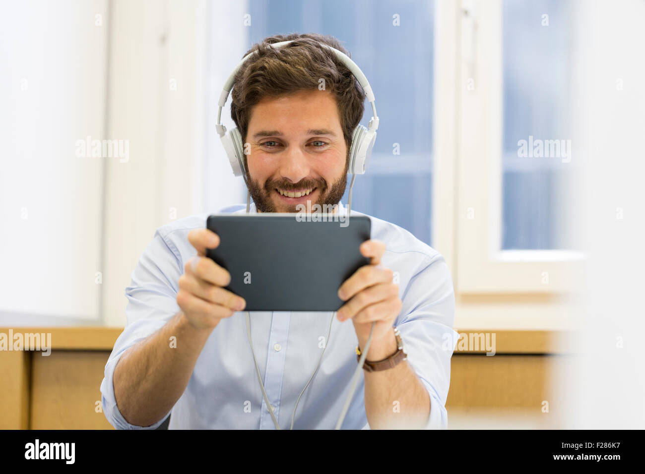 Kreative Geschäftsmann Kopfhörer anhören und mit digital-Tablette. Stockfoto