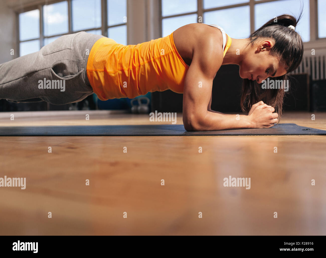 Junge Frau, Pilates, arbeiten an Bauchmuskeln zu tun. Muskulöse Frau dabei Core Training in der Turnhalle. Stockfoto