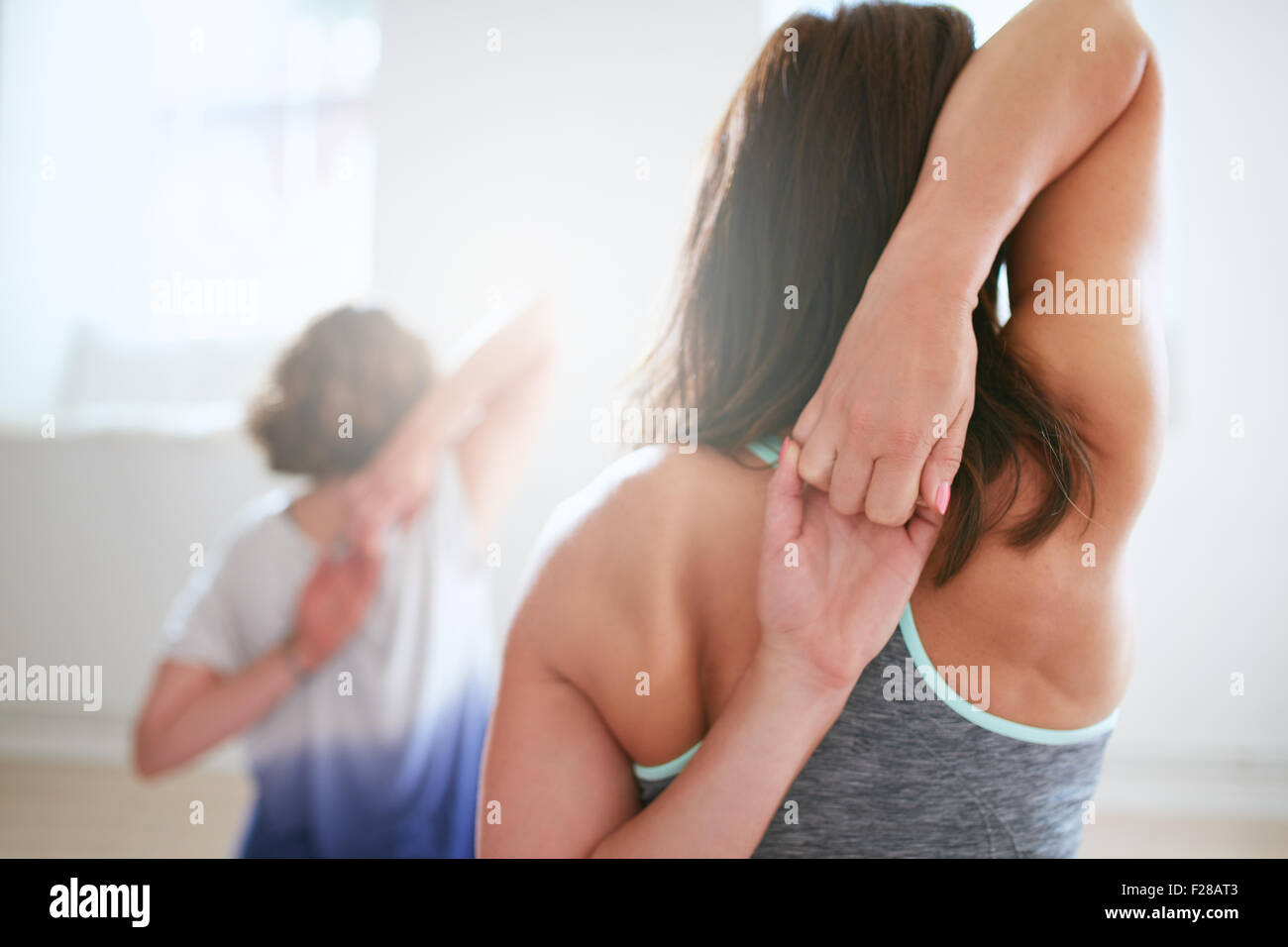 Heckansicht des Fit Frau Gomukhasana in Yoga-Klasse zu tun. Fitness Frauen Hand in Hand hinter ihrem Rücken und stretching. Trizeps eine Stockfoto