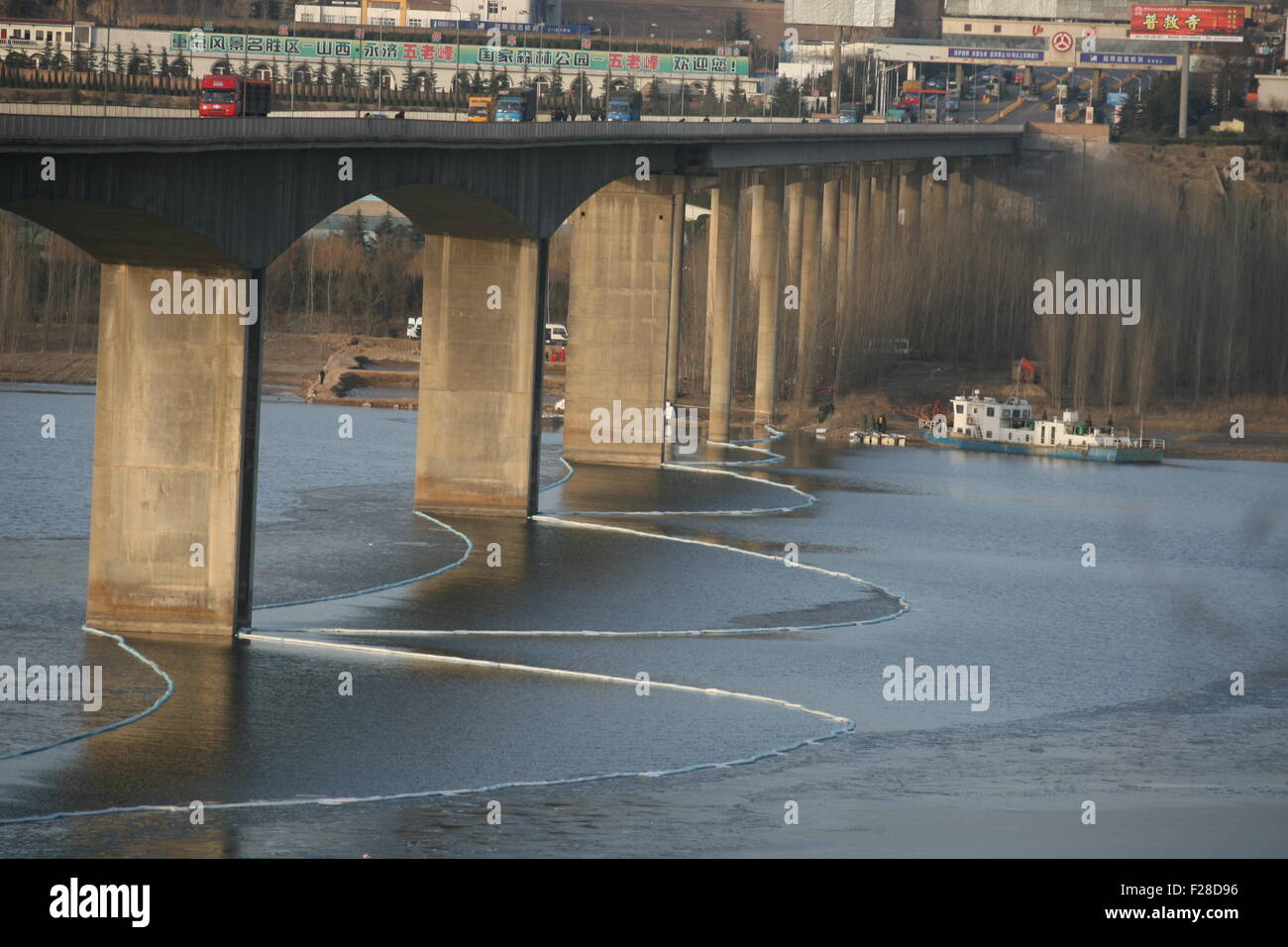 Eine temporäre Sperre mit Öl-absorbierenden Materialien ist geeignet, um Steuern, Diesel Öl Austritt aus einer Pipeline am gelben Fluss in Stockfoto