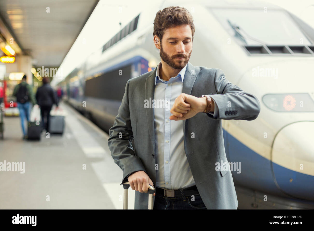 Mann sieht seine Uhr auf der Plattform-station Stockfoto
