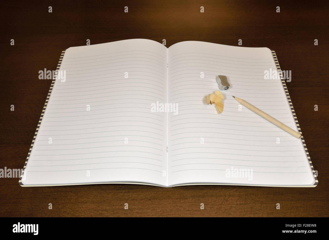 Notebook mit gespitzten Bleistift und Anspitzer auf hölzernen Schreibtisch geöffnet Stockfoto