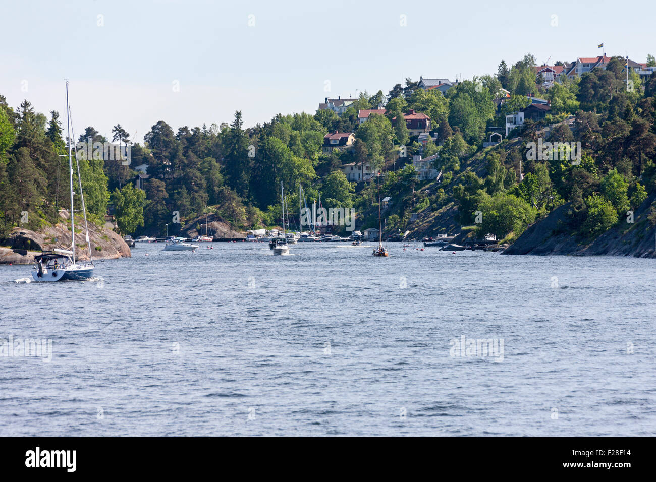 Segelschiffe in Meer mit Stadt im Hintergrund, Velamsund, Stockholm, Schweden Stockfoto