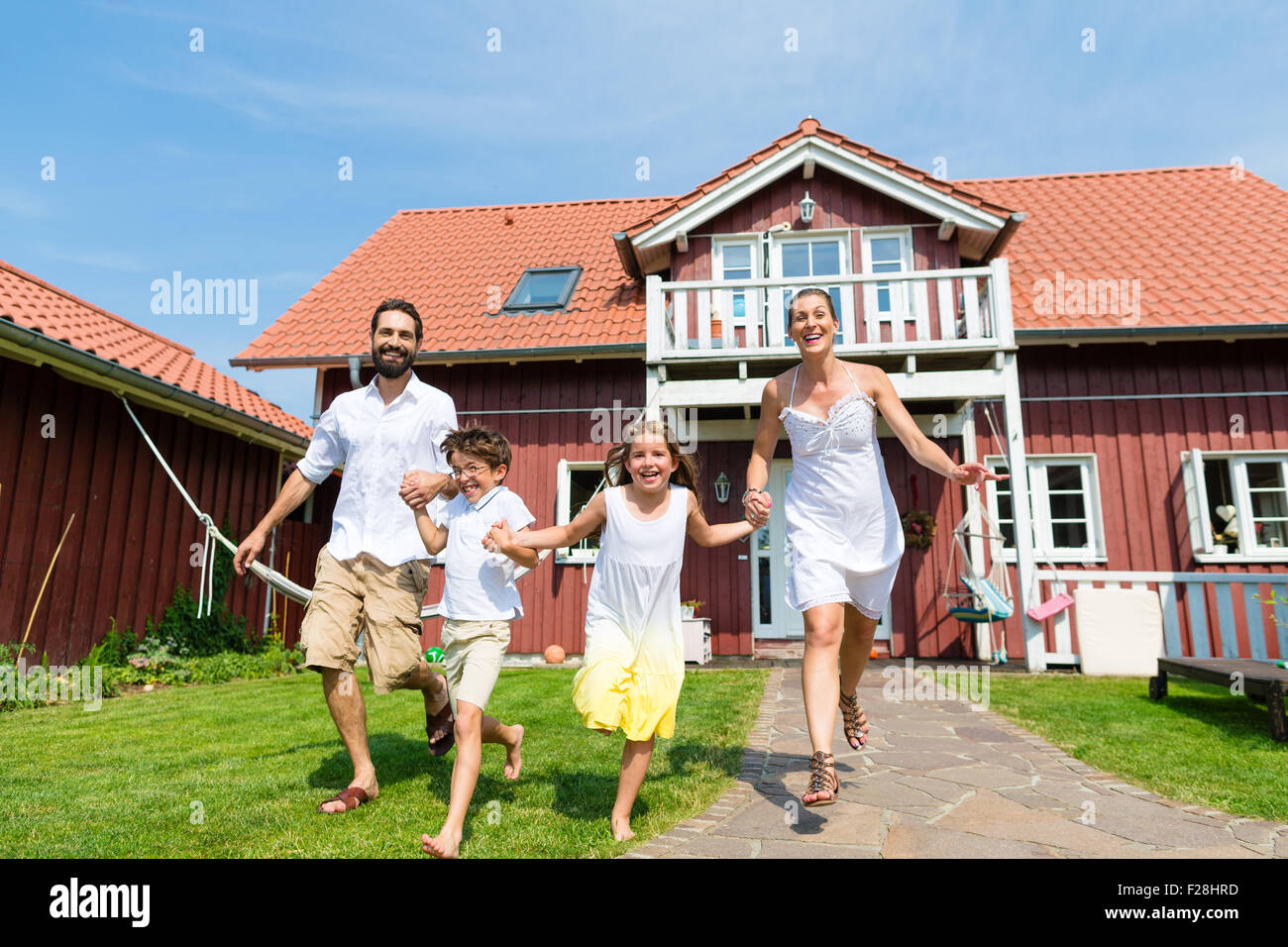 Familie Spaß mit ihrer Wohnung oder ein Haus durch den Vorgarten Stockfoto