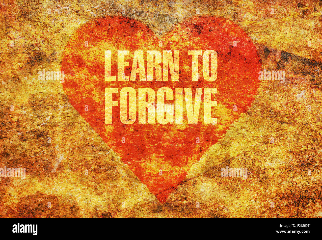 Text-Learn to Forgive geschrieben mit goldenen Buchstaben auf ein rotes Herz Stockfoto