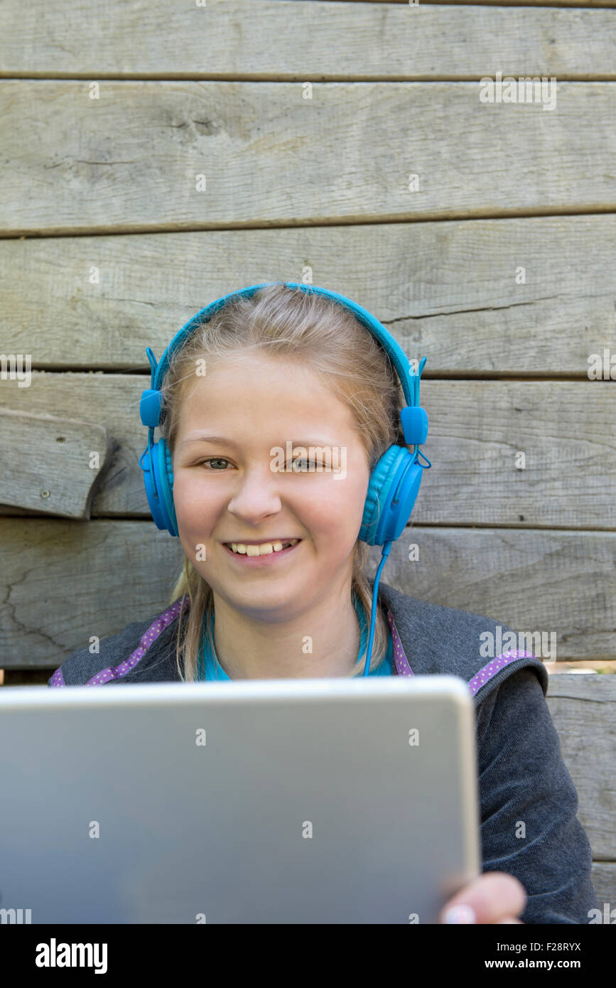 Mädchen Musik hören auf digital-Tablette auf Spielplatz, München, Bayern, Deutschland Stockfoto