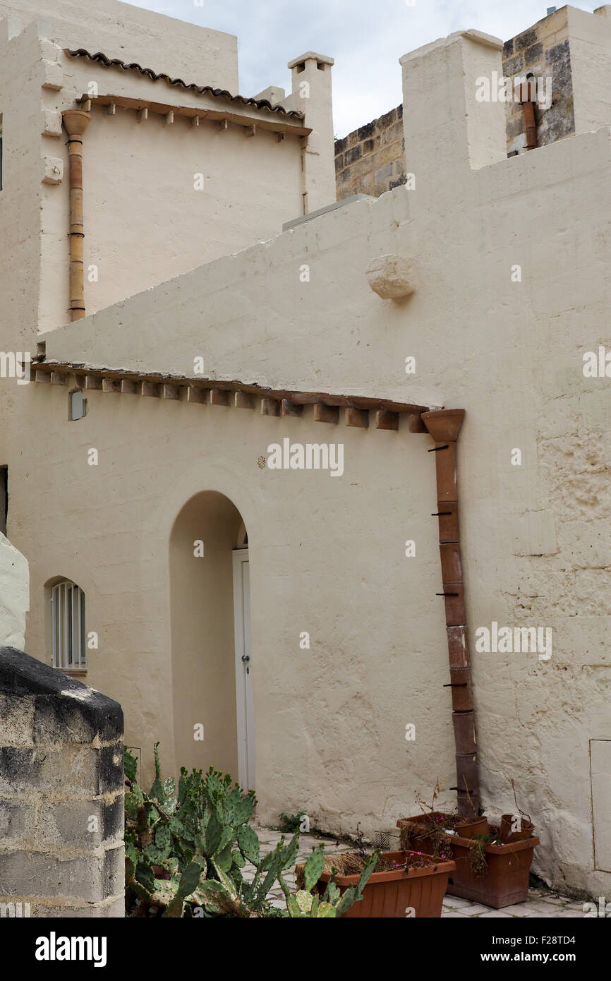 Ein Haus mit weiß getünchten Fassade und einem Fallrohr Dachrinne Stockfoto