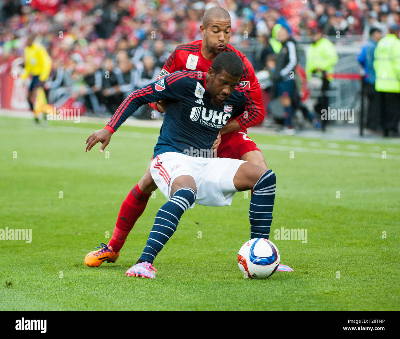 Toronto, Ontario, Kanada. 13. September 2015. New England Revolution Verteidiger Jeremy Hall (5) schirmt den Ball aus Toronto FC-Verteidiger Justin Morrow (2) in der ersten Hälfte im BMO Field in Toronto, ON, Kanada. Bildnachweis: Peter Llewellyn/Alamy Live-Nachrichten Stockfoto