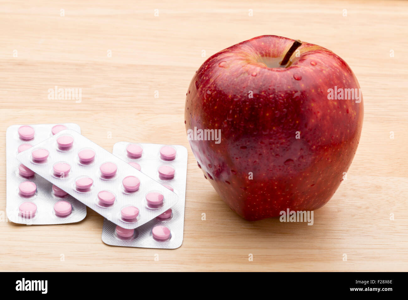 Rosa Pillen Blister Pack und frischer roter Apfel Stockfoto