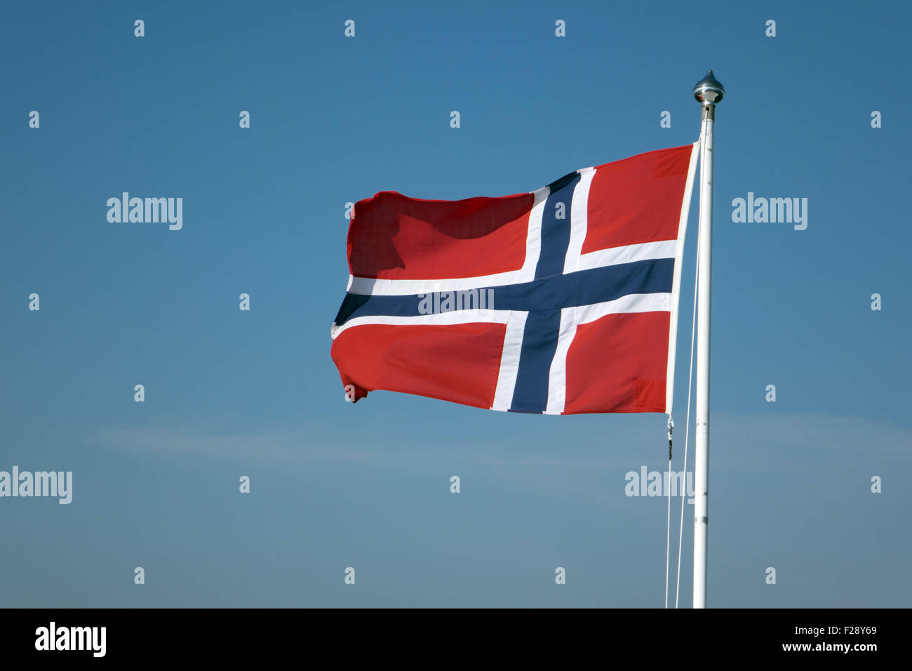 Norwegische Flagge flattern vor blauem Himmel Stockfoto
