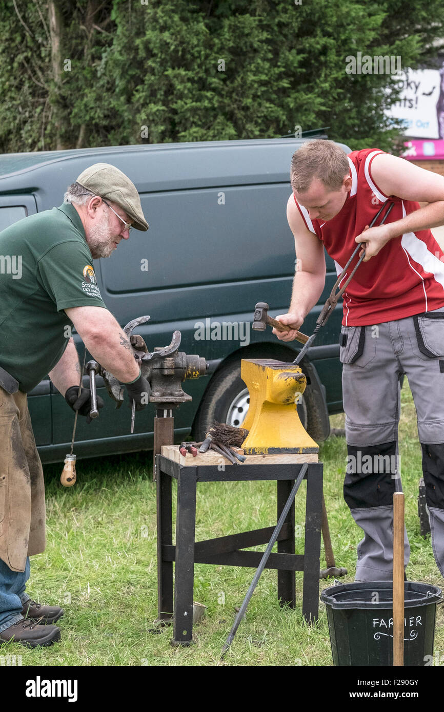 Ein Hufschmied und eine Schmiede arbeiten an der Essex Country Show, Barleylands, Essex. Stockfoto