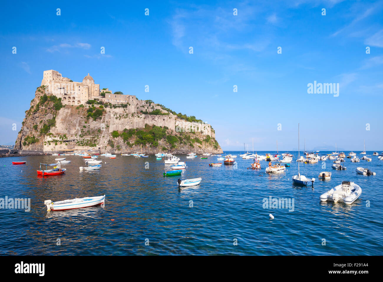 Küstenlandschaft von Ischia Porto mit Castello Aragonese und kleine Holzboote Stockfoto