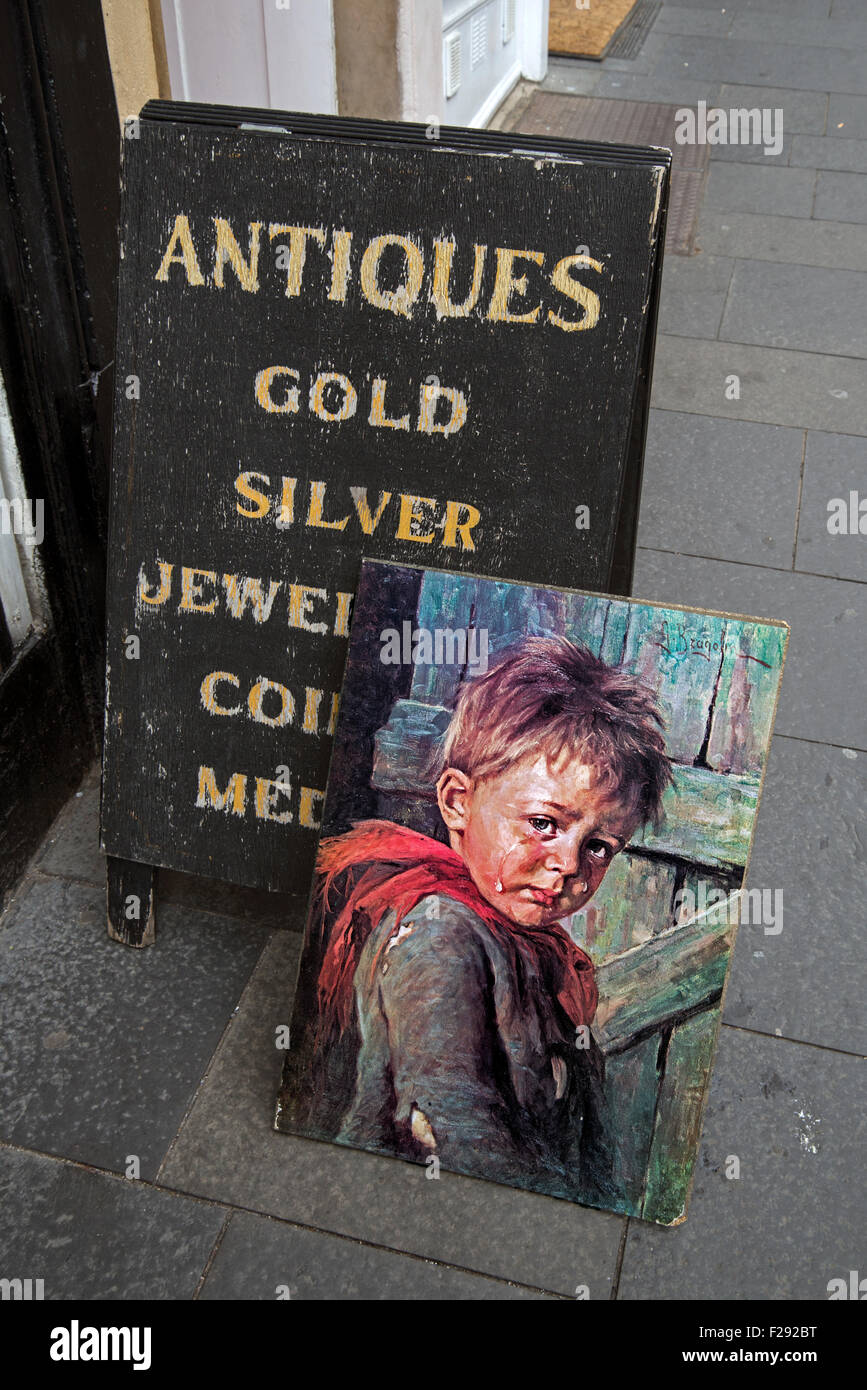 Kitschige Gemälde eines kleinen jungen Weinen neben einer pro Board Schild ein Antiquitätengeschäft in der Cockburn Street in Edinburghs Altstadt. Stockfoto
