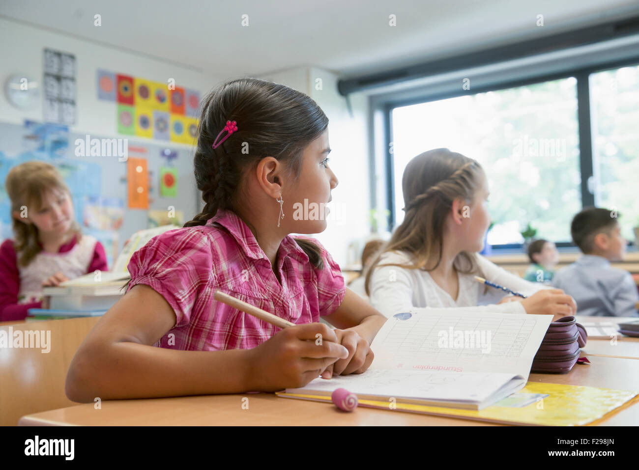 Schulschüler, die in Notizbüchern schreiben, München, Bayern, Deutschland Stockfoto