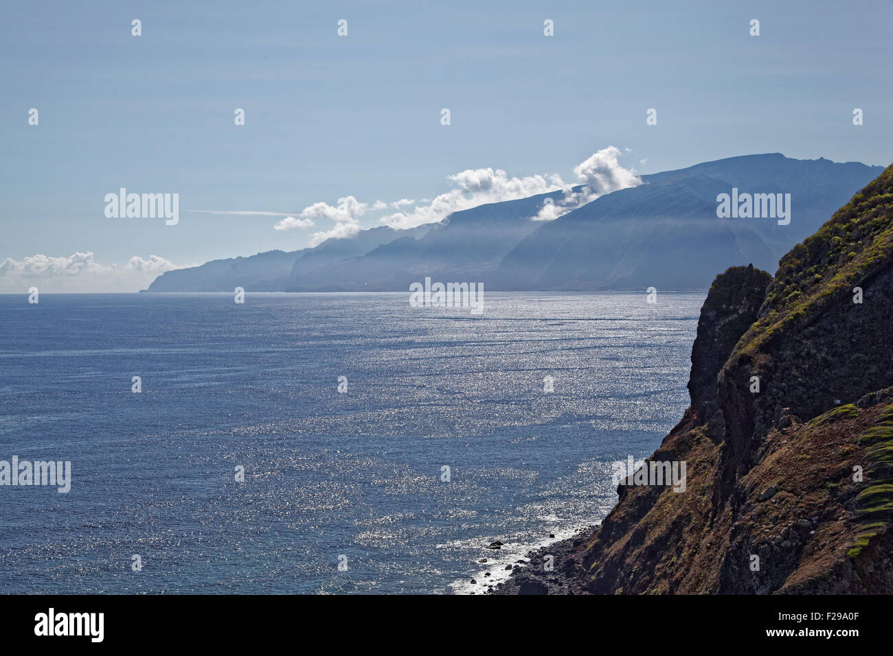 Hinterleuchtete - tops Contre Jour - Ozean-Szene mit Wolken und Nebel steigt vom Berg in der Nähe von Seixal, Madeira, Portugal Stockfoto