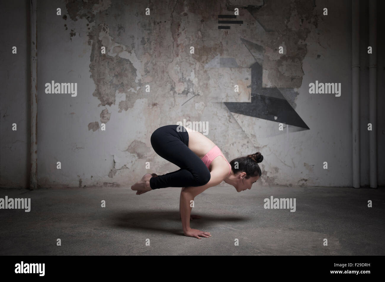 Mitte Erwachsene Frau üben Bakasana im Yoga-Studio, München, Bayern, Deutschland Stockfoto