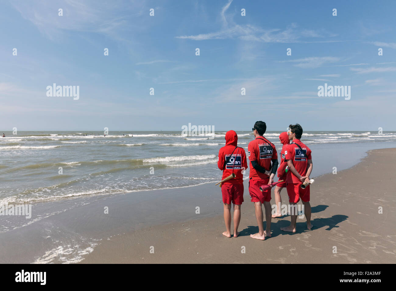 Vier junge Rettungsschwimmer beobachten das Meer vom Strand, Küste Nordsee, Belgien, De Haan, West-Flandern, Belgien Stockfoto