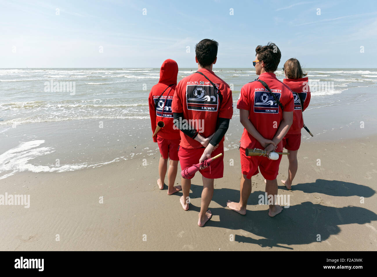 Vier junge Rettungsschwimmer beobachten das Meer vom Strand, Küste Nordsee, Belgien, De Haan, West-Flandern, Belgien Stockfoto