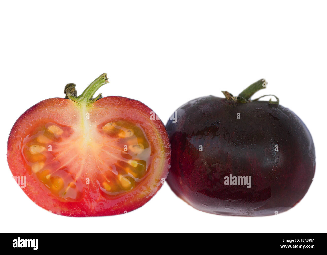 Schwarze Tomate "Indigo Rose", in Scheiben geschnitten, offen und ganz Stockfoto