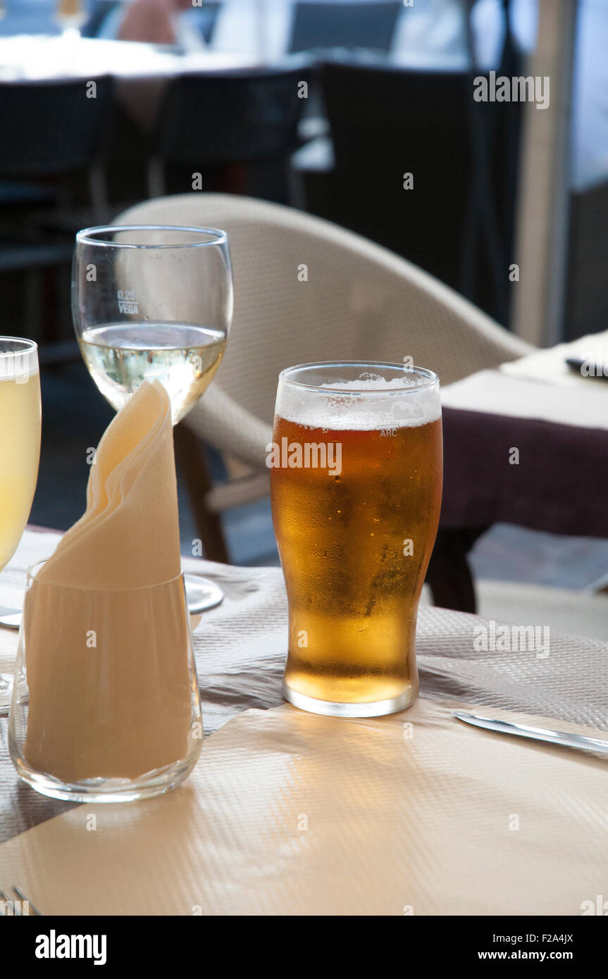 Pint Bier und ein Glas Wein auf einem Tisch. Stockfoto